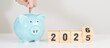 © Jo Panuwat D - 2025 end year to Happy New Year 2026 with piggy bank. Resolution, Goals, Plan, Action, Money Saving, Retirement fund, Pension, Investment and Financial concepts