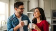 © attha - Happy young couple enjoying morning coffee together in their modern kitchen.