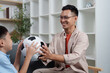 © itchaznong - Family Life: Father and son playing with a soccer ball at home