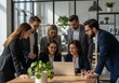 © Mostafiz - A group of business professionals collaborating around a laptop in a modern office environment
