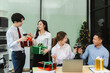 © NINENII - Asian people, celebrating together and gift exchange at Merry Christmas & Happy New Year. excited businessman feel happy work complete and celebration successful deal.