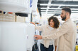 © Serhii - Couple choosing water heater in electronics store