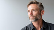 © perfectlab - Portrait of thoughtful mature man with beard looking away against neutral background in casual shirt