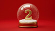 © ink drop - Snow globe with golden number 2 resting on snow against a vibrant festive red background. 12 days of christmas