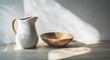 © GH - Elegant White Pitcher and Wooden Bowl on a Light Surface With Soft Shadows