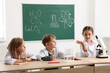 © New Africa - Group of children with microscope studying at desk in class. Little scientists