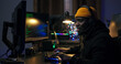 © ABCreative - Guy in a yellow cap sits at desk getting ready to play a video game with a friend, puts on a headset, greets team, warms up his hands before clicking on the keyboard.