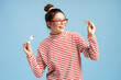 © Maria Vitkovska - Young woman smiling, holding two pairs of eyeglasses, choosing the perfect fashion accessory