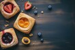 © Tasnim - Freshly baked danish pastries with strawberry apricot and blueberry fillings on dark wood