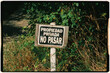 © Adrian Rodd/Stocksy - Analog image of a small sign warning that this is private property