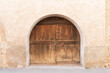© Lawren Lu/Stocksy - Rustic Wooden Arch Door in Weathered Stucco Wall