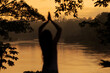 © Luis Herrera/Stocksy - Silhouette of woman meditating in tropical rainforest at sunrise