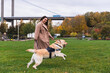 © Diego Martin/Stocksy - Young Woman Playing with Her Energetic Labrador Dog in a Park