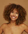 © Leandro Crespi/Stocksy - Smiling Woman With Curly Hair Against a Simple Background