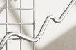 © Giada Canu/Stocksy - 3D render close-up of curved arrow on a white grid wall