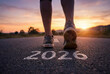 © Patrick - Runner stepping forward on an open road at sunrise with 2026 painted on asphalt, fitness motivation and new year goal setting for training, progress and personal growth