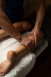 © vfhnb12 - Close-up of a professional therapist giving a leg massage in a spa, applying oil and pressure with hands to relax muscles, improve circulation, and promote wellness in a calm environment.