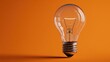 © Oleksandr - Glowing light bulb from above on a warm orange surface representing inspiration and innovation
