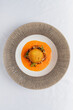 © Maksim Shebeko - A stunning dish features a golden croquette atop vibrant sauce and fresh herbs
