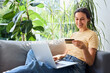 © baranq - Woman at home using laptop paying with credit card for online shopping
