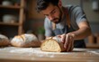 © Benjamin - Close up of young man on artisanal sourdough bread production on small bakery. New normal covid-19 economic recovery profession change storytelling concept. High quality