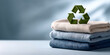 © perfectlab - Stack of folded sustainable clothing with green recycling symbol on top representing eco-friendly fashion and textile recycling concept