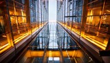 glass atrium skyscraper interior looking up with modern elevator architecture and yellow lights
