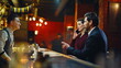 © stockbusters - Business pair stepping lounge ordering drink. Guest choosing alcohol beverages
