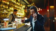 © stockbusters - Emotional man yelling smartphone call at night bar closeup. Guy drinking bourbon