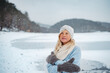 © Halfpoint - Senior woman enjoying snowfall in winter landscape.