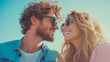 © sommersby - Joyful young couple with curly hair and stylish sunglasses sharing happy moment outdoors, gazing at each other with beaming smiles under clear sunny sky