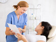 © JackF - Professional beauty specialist giving documents to patient in procedure cabinet in hospital