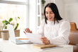 © Pixel-Shot - Happy businesswoman with refund form at table in office