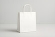 © melano - Elegant white shopping bag mockup for branding and retail design projects displayed on a neutral surface ready for your logo or design