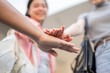 © bongkarn - Close up of woman student and friends joining hand together while standing below university building