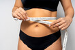 © Alfonso Soler - Woman measuring waist with tape for weight loss