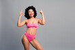 © deagreez - Confident young woman in pink bikini poses with a cheerful smile promoting fitness lifestyle and body positivity