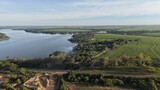 Aerial view of a river surrounded by green fields and lush vegetation