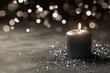 © Aleksey - Glittering Black Candle with Bokeh Lights on Shimmering Dark Surface.