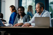 © Suteren Studio - Smiling Black Woman Leading Feedback Session Meeting in Modern Open Office