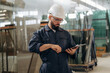© standret - Confident look, quality control. Warehouse worker in an industrial environment of a factory or storage area