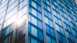 © Tmack - Stunning modern glass skyscraper facade reflecting bright sunlight in a dynamic urban setting