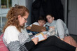 © Мар'ян Філь - Mom and children at home playing the board game sea battle, weather is bad outside and they are sitting at home and enjoying communication and playing together