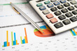 © Warawan - Calculator with pen on data business graphs paper.