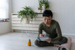 © lordn - Woman in sportswear sitting on floor by yoga mat, writing in notebook and reflecting after home workout or yoga session