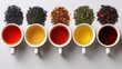 © Abba - Five cups of various teas are arranged next to their corresponding dry leaves. Showcase different tea varieties, flavors, and brewing strengths.