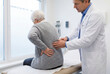© David Zarzosa - Elderly woman with back pain examined by doctor in medical clinic.