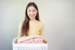 © Pormezz - woman holding stack of laundry clothes
