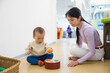 © leungchopan - Little baby playing with mother in indoor playhouse