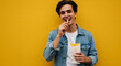 © Ronald Red - Young caucasian man eating french fries, holding paper bag. Happy person enjoying street takeaway fast food meal. Advertising banner with copy space.